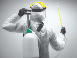addetto alla sanificazione di spalle con dispositivi di sicurezza e macchinario apposito